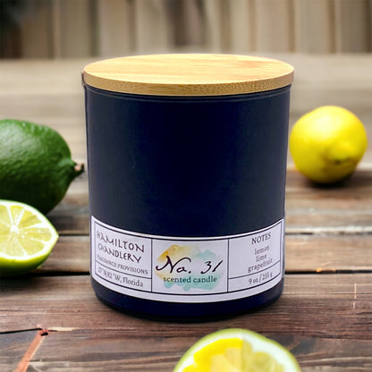 Fragrance No. 31 Blown Glass Candle with Lemon and Limes in Background on Wooden Table | Hamilton Chandlery