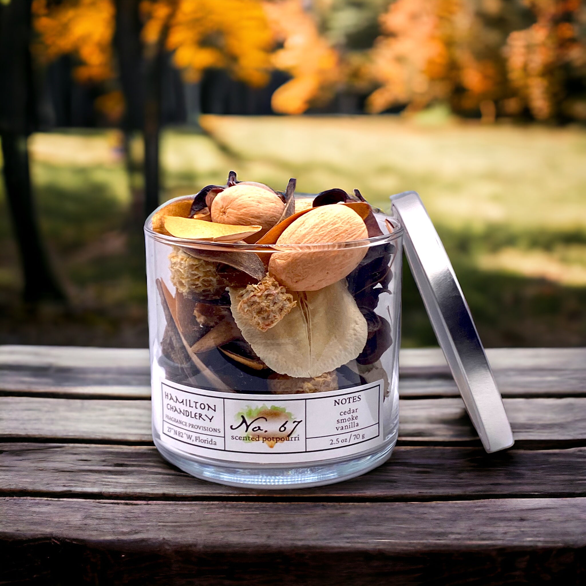 Fragrance No. 67 Potpourri Jar on Wooden Bench with Autumn Forest Background | Hamilton Chandlery