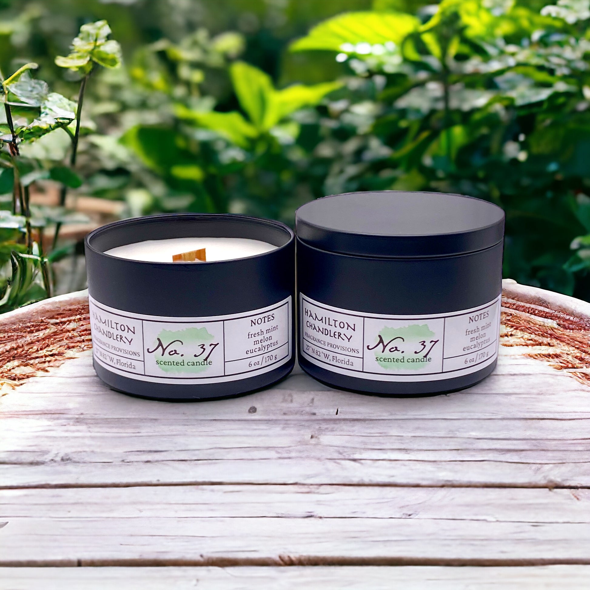 Fragrance No. 37 Travel Tin Candles on Wooden Table with Mint Garden in Background | Hamilton Chandlery